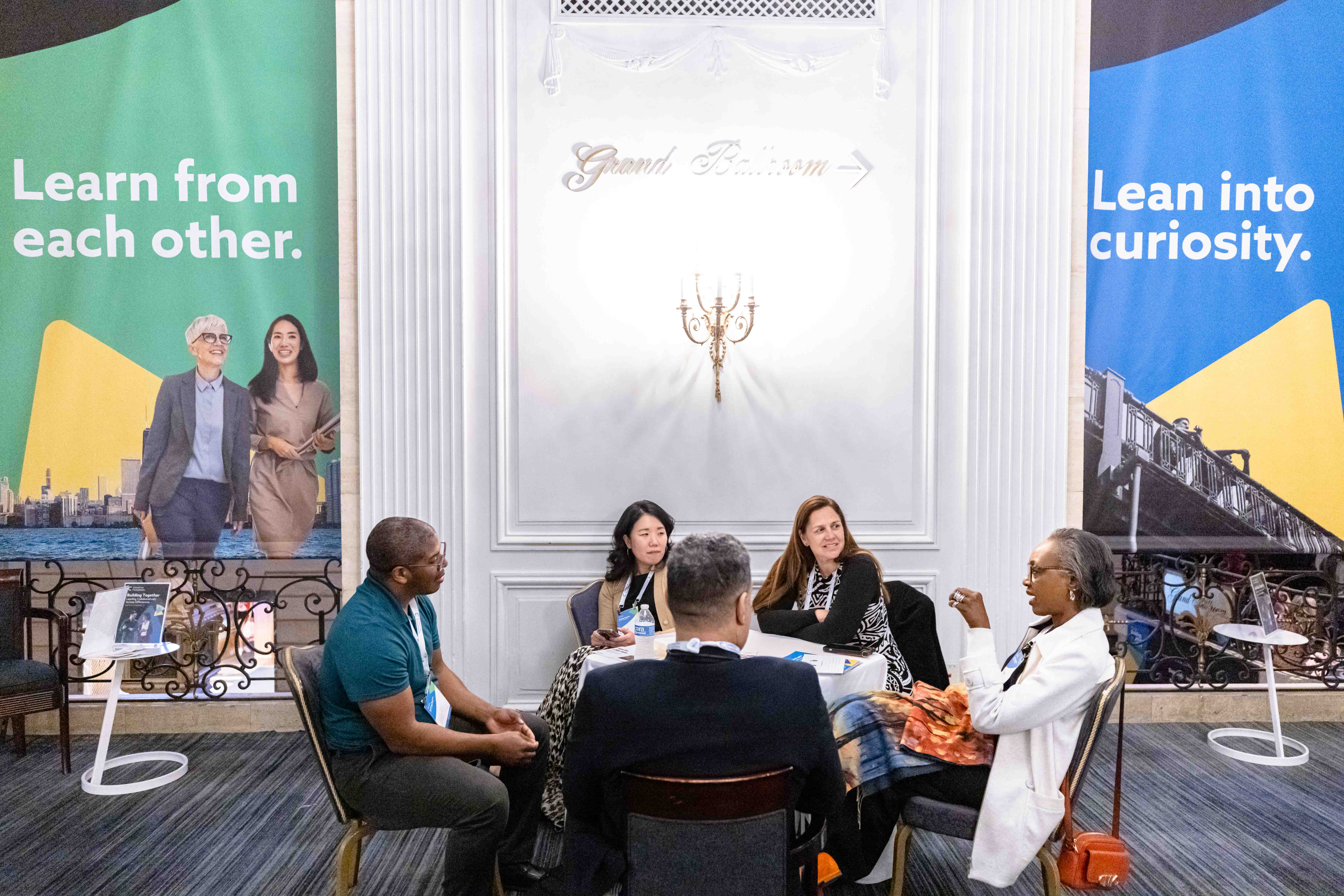 Building Together 2024, Chicago IL, people at lounge chairs with conference signage