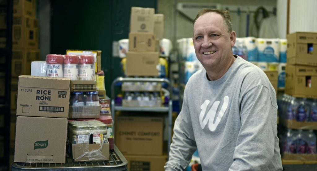 North Dakota, Man smiling with food pantry boxes, Bush Foundation