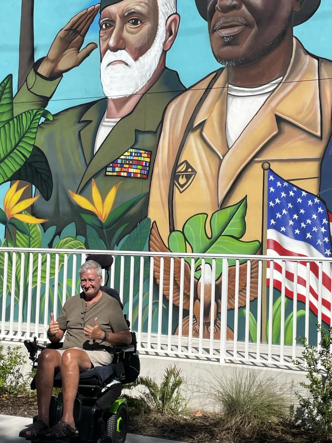 Heroes' Village—Sarasota, man by mural in electric wheelchair