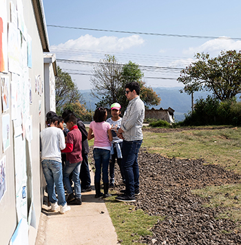 Juan Constain of Public Equity Group listens to students talk about their art and science projects funded by the BBCA partnership.