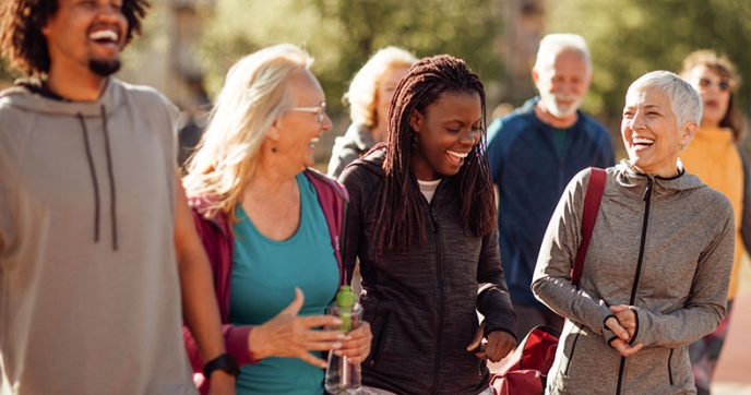 A diverse group of people walks outside