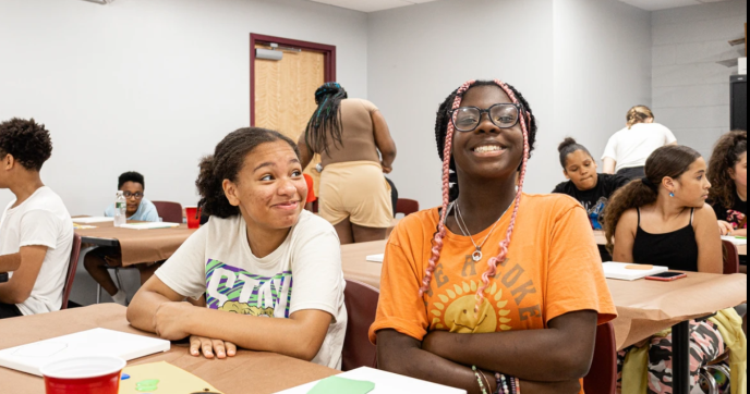 Academic Leadership Association Students look on smiling in a classroom.