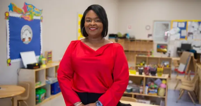 Felicia Lucky, standing and smiling in a classroom photographed for the Montgomery Advisor